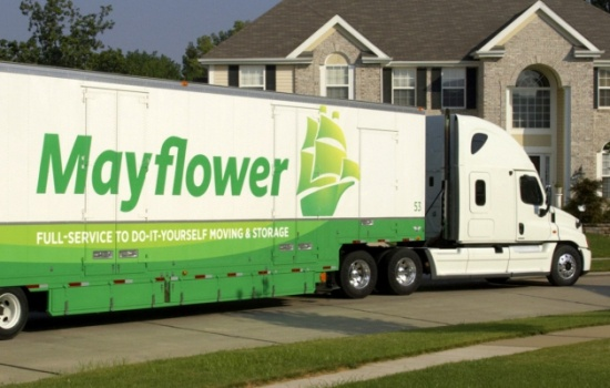 Mayflower moving truck parked in front of a suburban house.